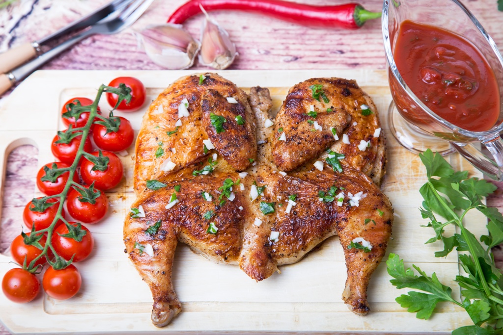 Fried chicken tobacco (tabaka) on the board. Selective focus, close up.